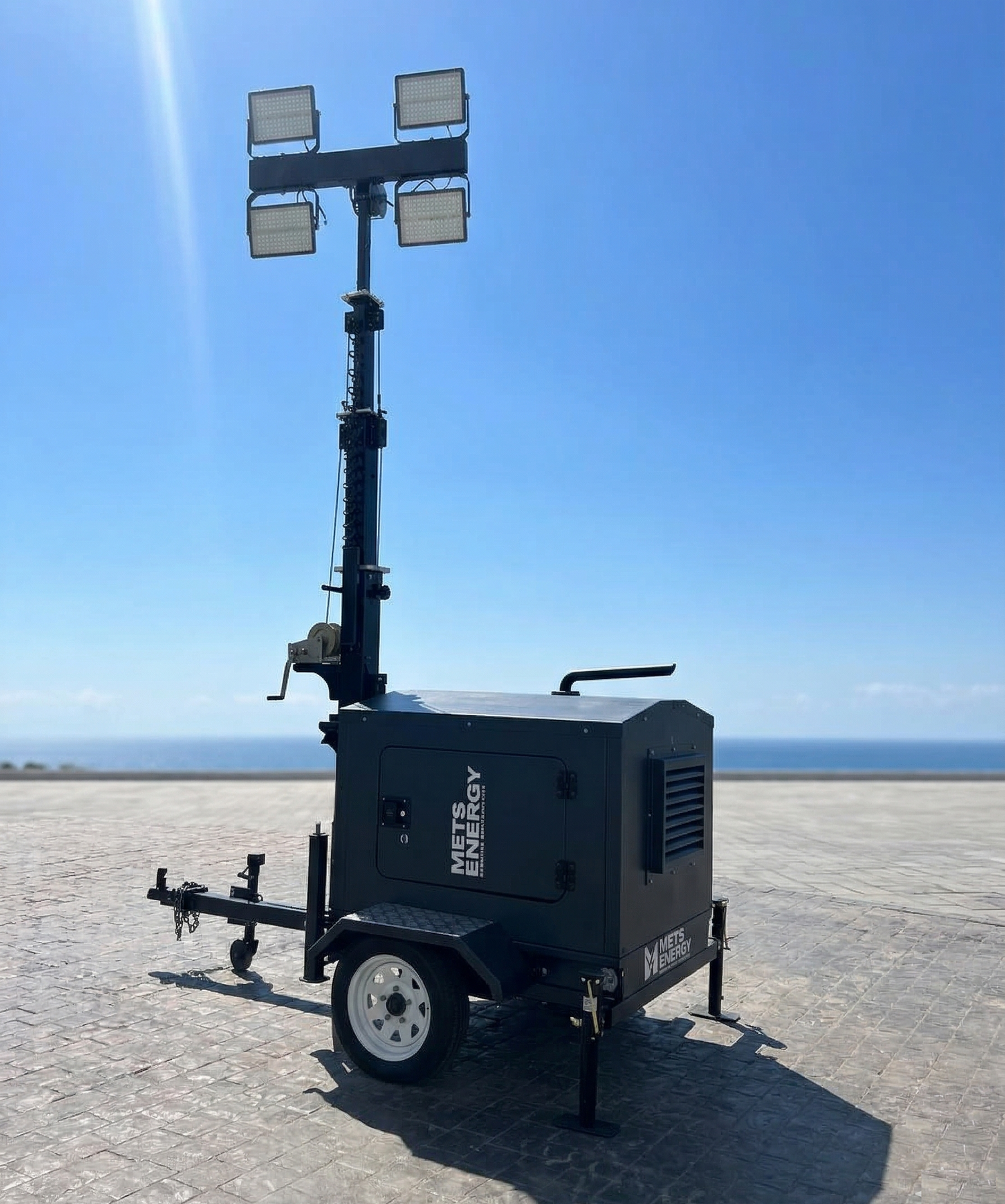 Portable light tower on a trailer with a clear blue sky background